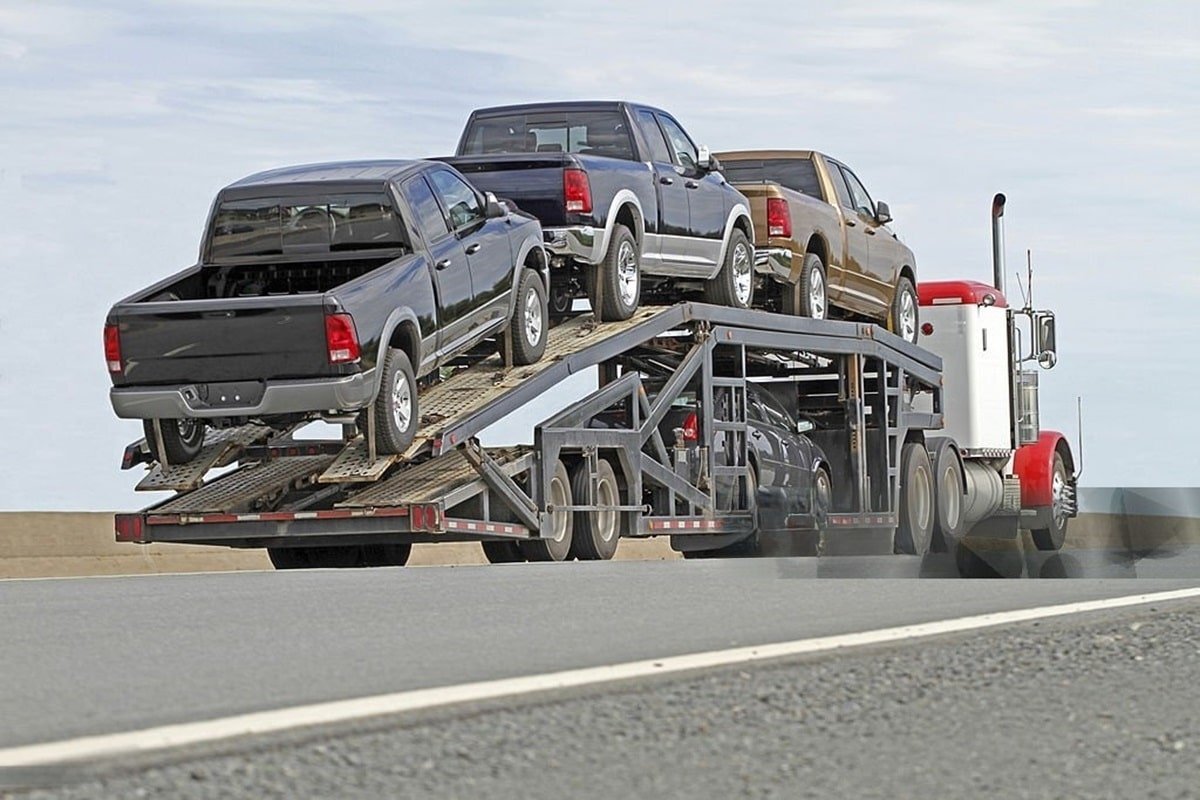 a truck carrying cars on a flatbed trailer